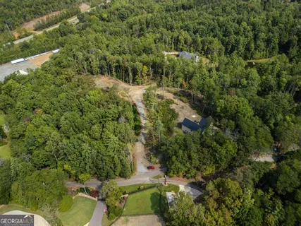 an aerial view of residential house with outdoor space and trees all around