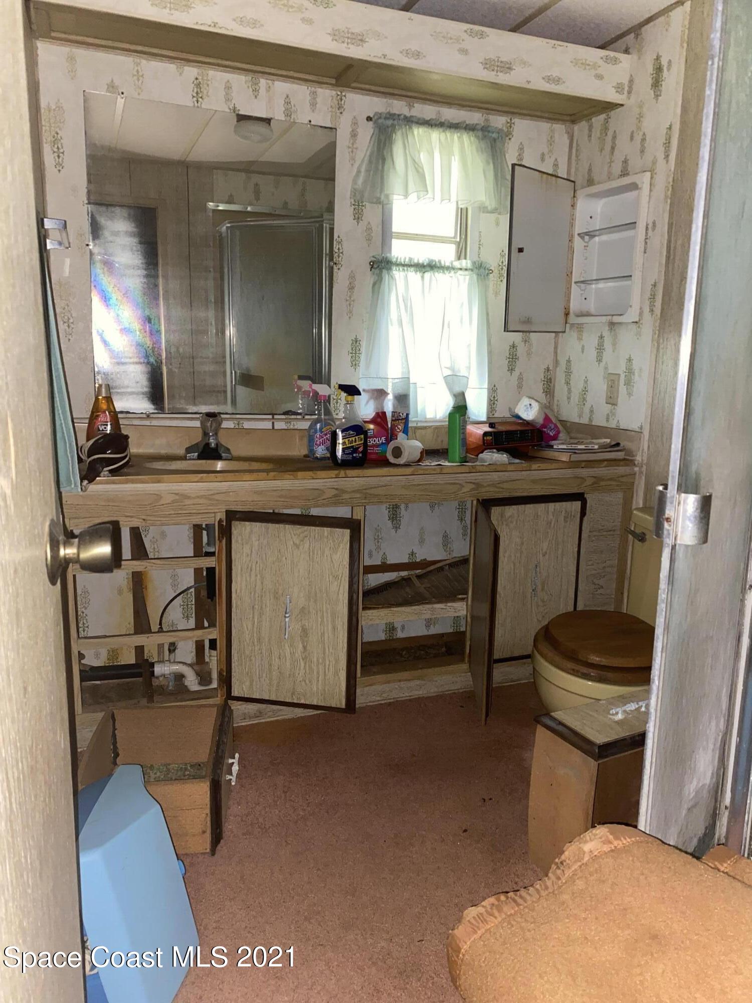 3370 Turnbull Road Mims, FL 32754 - Photo 3 of 13 a bathroom with a sink a toilet and a mirror