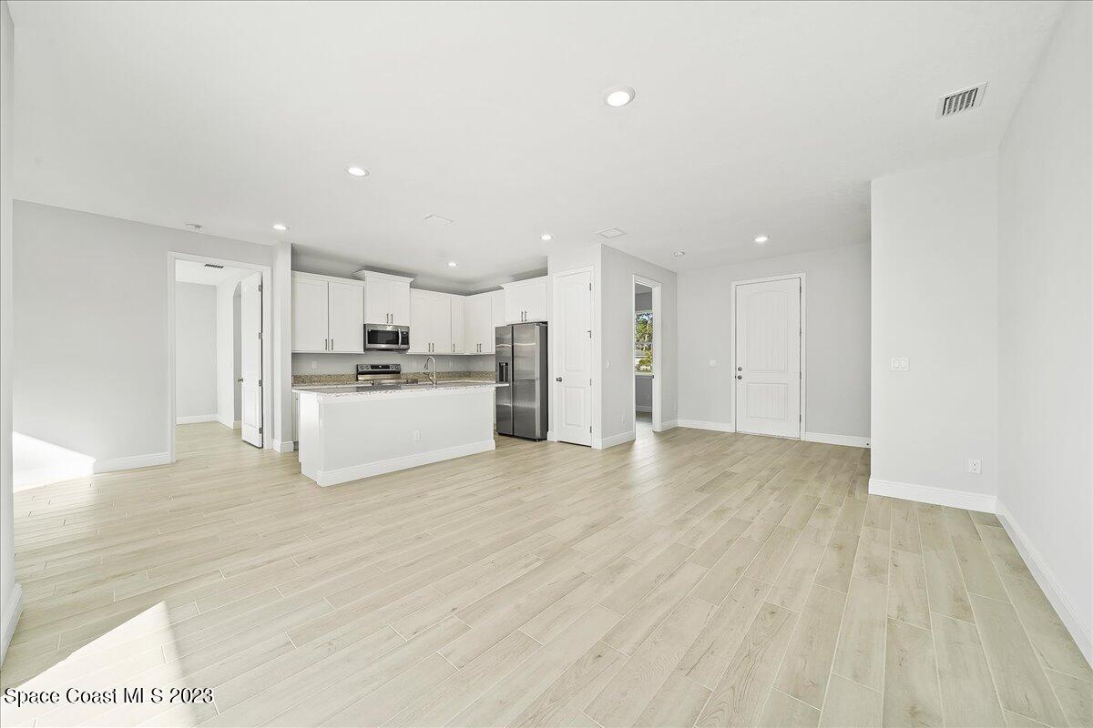 560 Topeka Road Southwest Palm Bay, FL 32908 - Photo 8 of 26 a view of a kitchen with a sink and a refrigerator