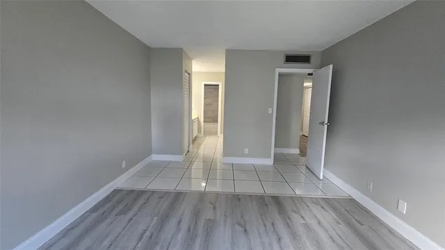 an empty room with wooden floor and entrance