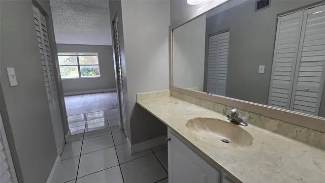 a bathroom with a granite countertop sink and a mirror