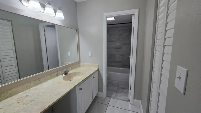 a bathroom with a granite countertop sink and a mirror