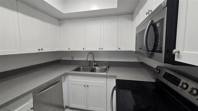 a kitchen with a sink cabinets and appliances