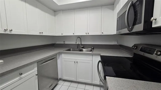 a kitchen with a sink dishwasher and cabinets