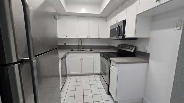 a kitchen with a sink a stove and cabinets