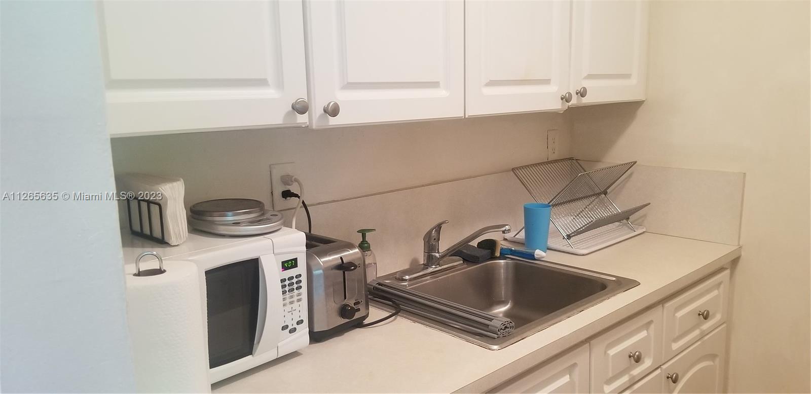 2920 Southwest 28th Terrace, Unit 304 Miami, FL 33133 - Photo 13 of 26 a kitchen with a sink and cabinets
