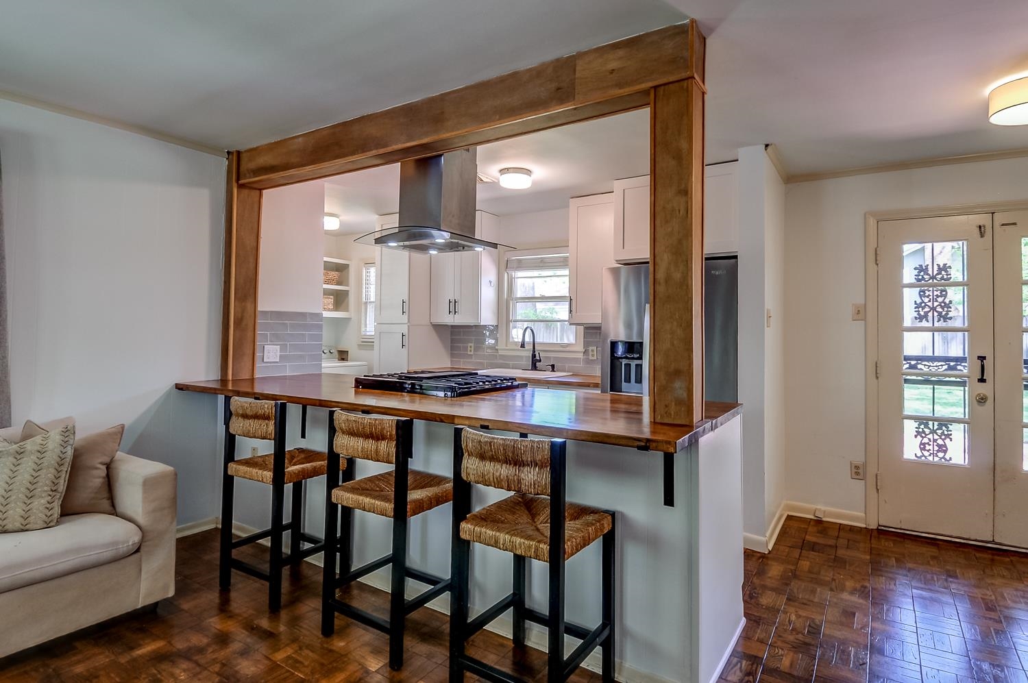 5056 Wingdale Road Memphis, TN 38117 - Photo 6 of 18 Kitchen featuring decorative backsplash, white cabinets, wooden counters, parquet floors, and island range hood
