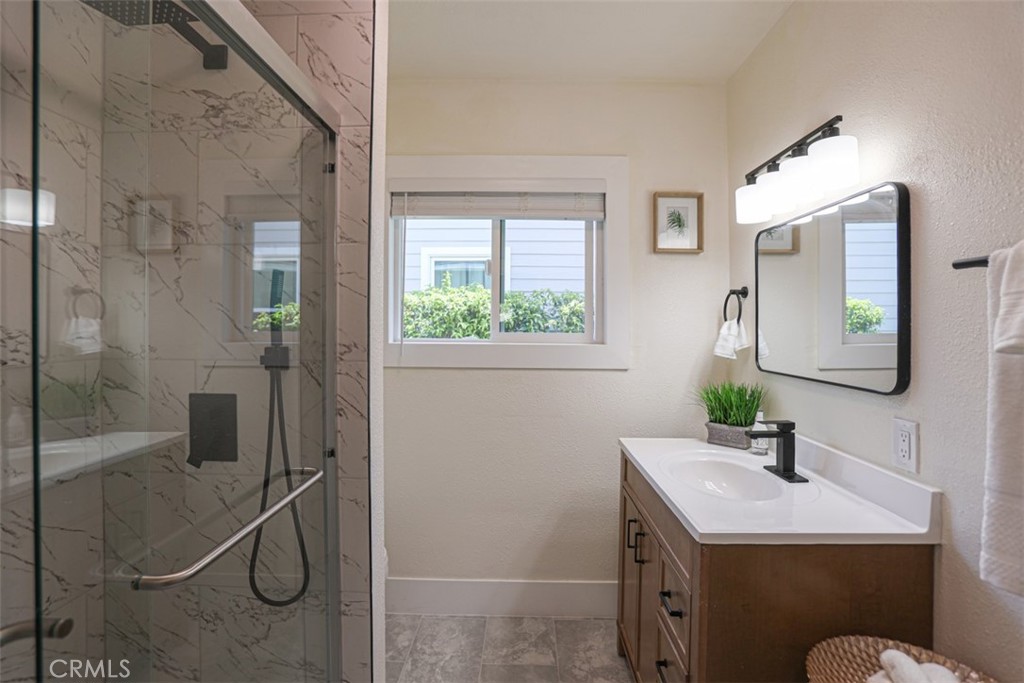 600 South Emily Street Anaheim, CA 92805 - Photo 14 of 22 a bathroom with a granite countertop sink a mirror and a shower