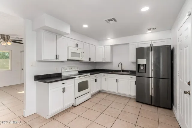 a kitchen with granite countertop appliances cabinets and a sink