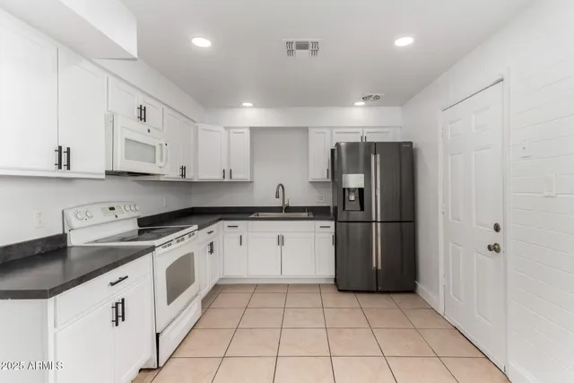 a kitchen with stainless steel appliances granite countertop a refrigerator sink and cabinets
