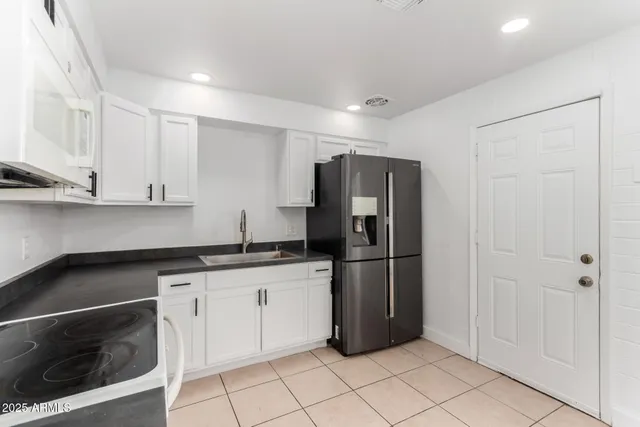 a kitchen with stainless steel appliances granite countertop a refrigerator and a sink