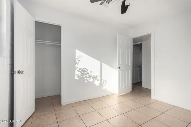 an empty room with windows and closet