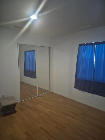 an empty room with wooden floor and cabinet