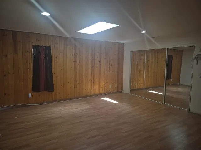 an empty room with wooden floor and sliding door