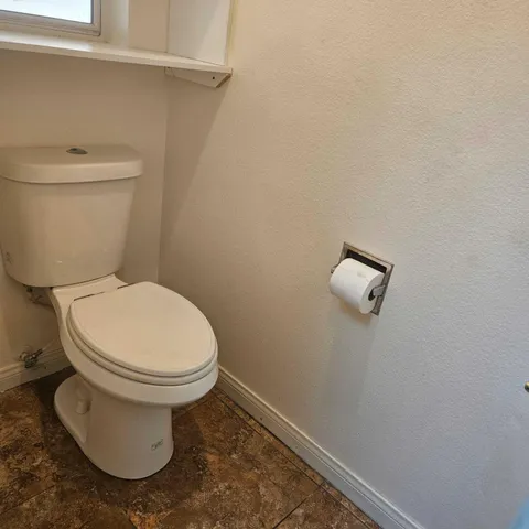 a white toilet sitting next to a white wall