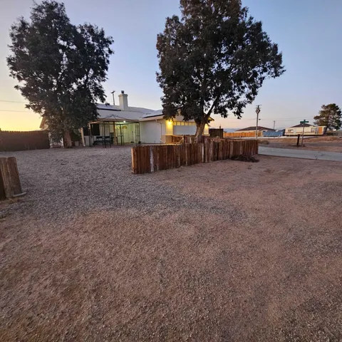 a view of a house with a yard and tree