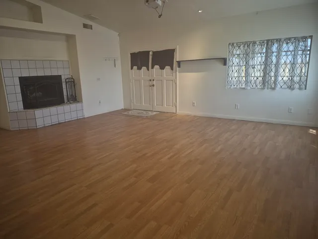 an empty room with windows and fireplace
