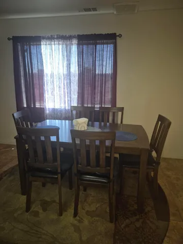a view of a dining room with furniture and window