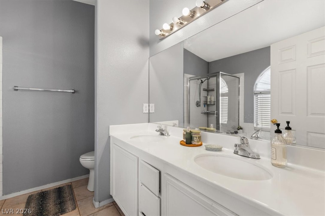 2377 Ramsgate Drive Henderson, NV 89074 - Photo 16 of 25 Double vanity with ample counter space and an adjacent shower, offering practical bathroom design.