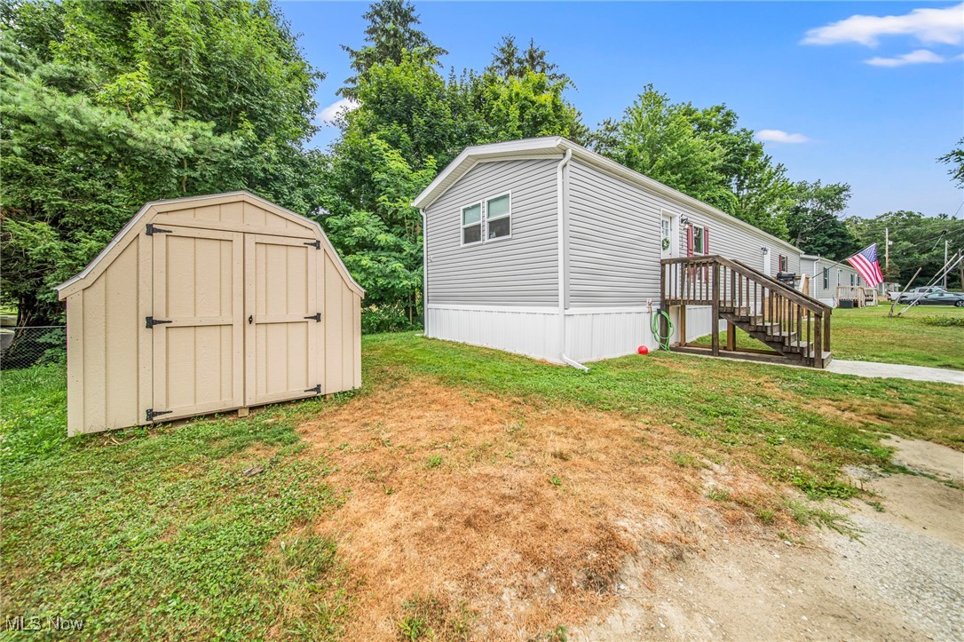 202 West Main Road, Unit LOT 13 Conneaut, OH 44030 - Photo 2 of 23 View of side of home with a shed and view of wooded area