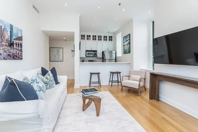 a living room with furniture a rug and a flat screen tv