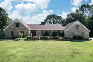 a view of a house with a yard and sitting area
