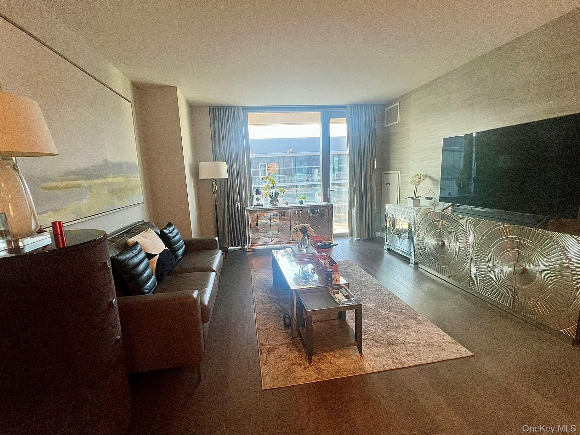 131-03 40 Road, Unit PH2G Queens, NY 11354 - Photo 2 of 29 a living room with furniture and a flat screen tv