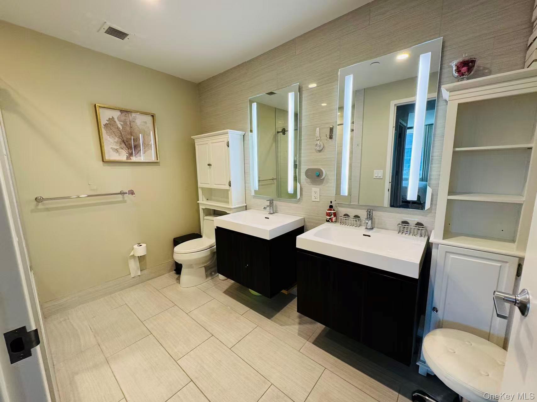 131-03 40 Road, Unit PH2G Queens, NY 11354 - Photo 6 of 29 a bathroom with a double vanity sink toilet and mirror