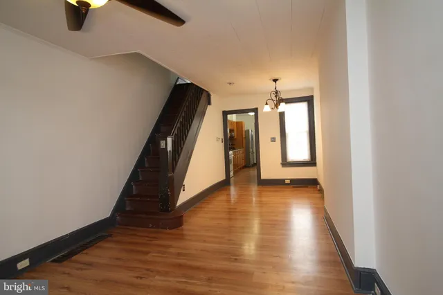 a view of a hallway with wooden floor and staircase