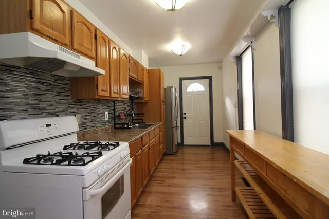 a kitchen with a sink a stove and cabinets