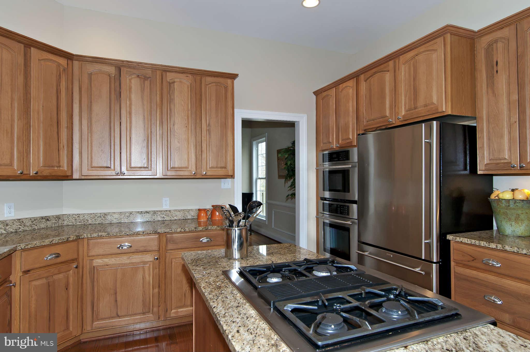 8407 Old Georgetown Road Bethesda, MD 20814 - Photo 9 of 30 a kitchen with wooden cabinets and stainless steel appliances