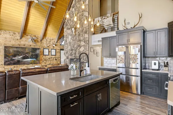 a kitchen with stainless steel appliances granite countertop a sink a stove and chairs