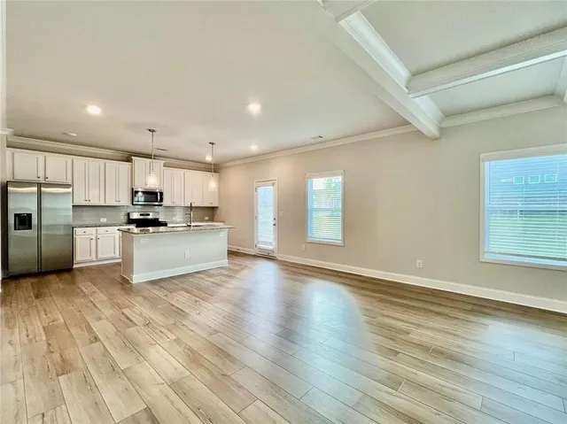 a view of kitchen with wooden floor and electronic appliances