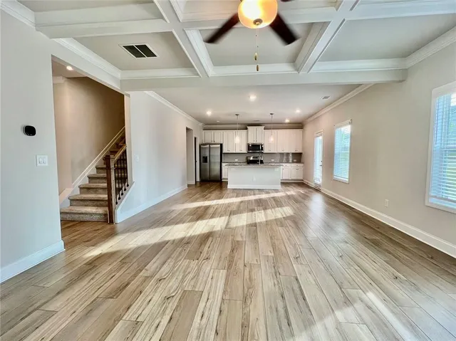 a view of a living room with wooden floor and staircase