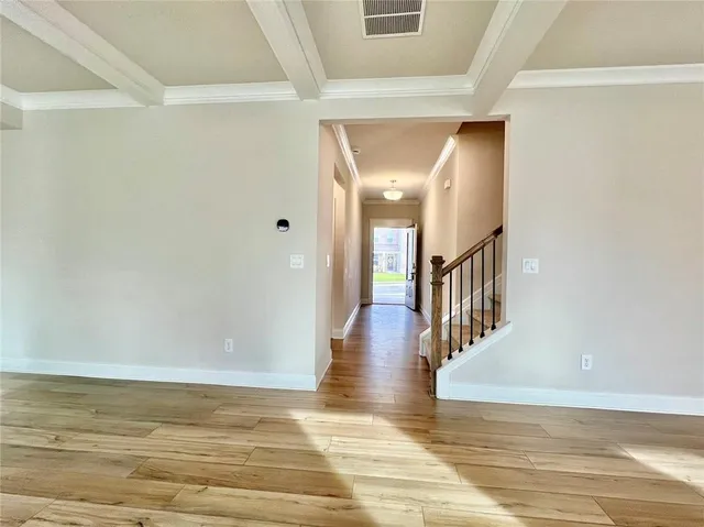 a view of a hallway with wooden floor and staircase