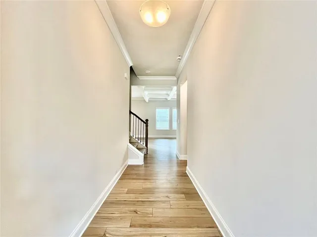 a view of a hallway with wooden floor and staircase