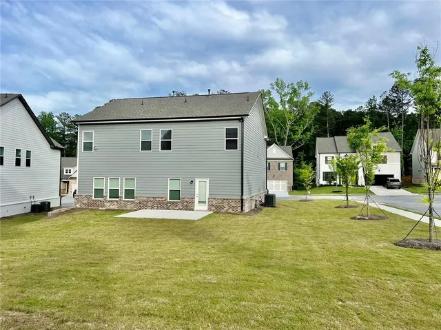 a view of a house with a yard and a table and chairs under an umbrella