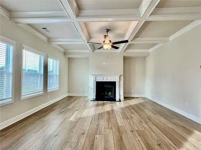 a view of empty room with wooden floor and fireplace