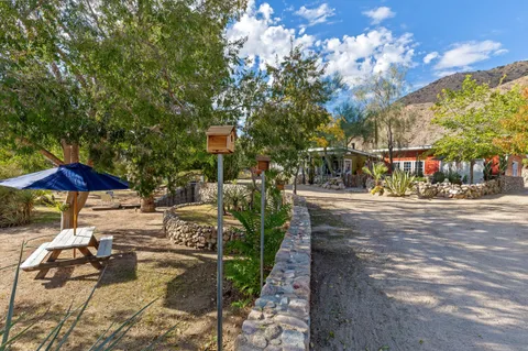 a balcony with a table and chairs and wooden fence