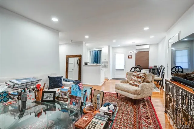 a kitchen with stainless steel appliances granite countertop a dining table chairs refrigerator and sink