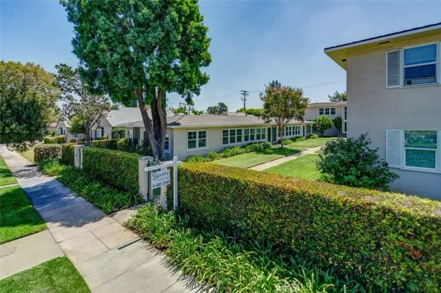 a view of a house with a big yard and large trees