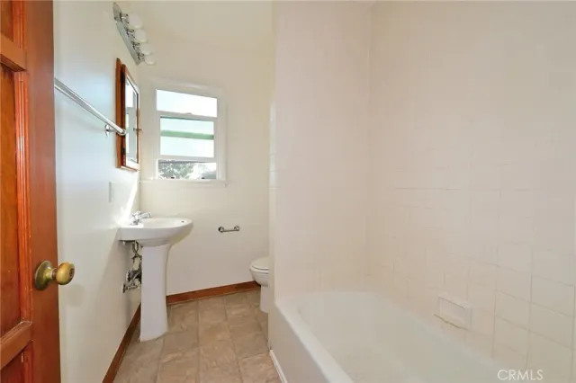 a hallway with a wooden floor and windows