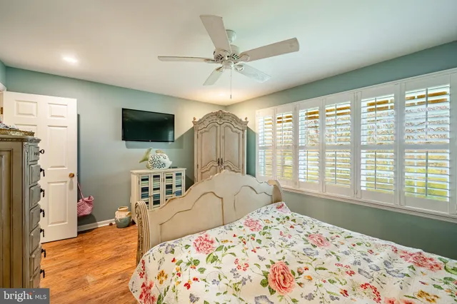 a bedroom with a bed window and a flat screen tv