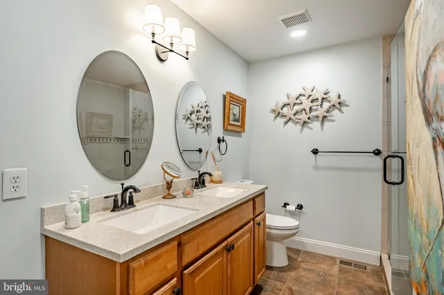 a bathroom with a double vanity sink mirror and toilet
