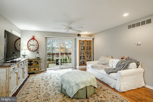 a living room with furniture a flat screen tv and a large window