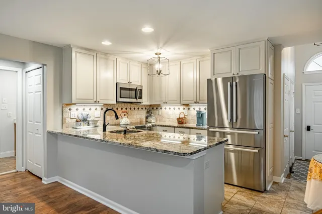 a kitchen with stainless steel appliances granite countertop a refrigerator and a sink