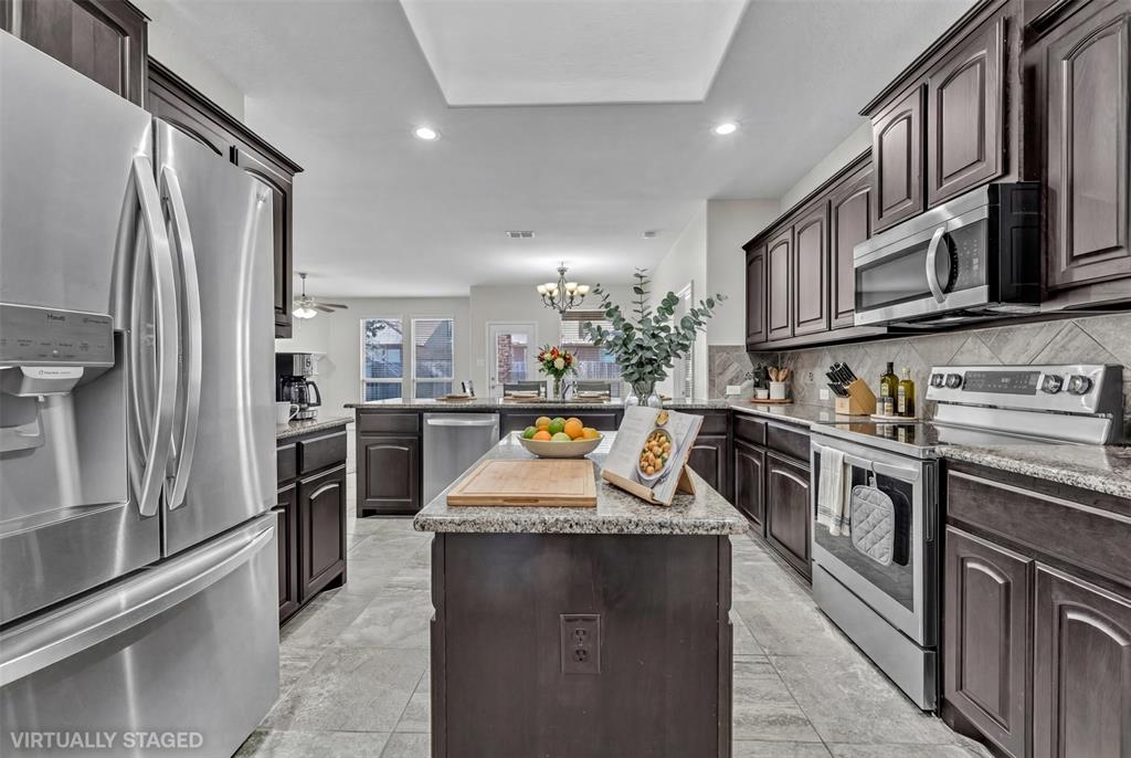 a kitchen with stainless steel appliances granite countertop a stove a sink and a refrigerator