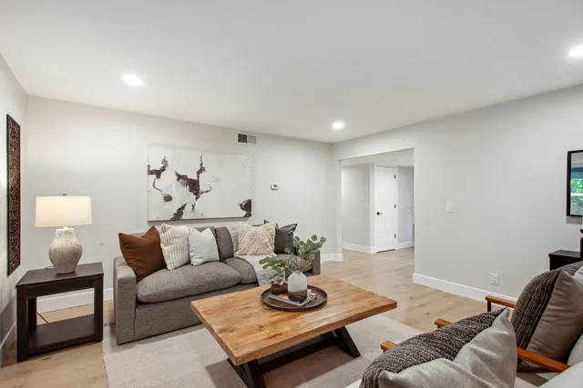 a living room with furniture and a wooden floor