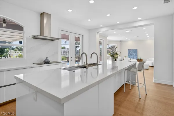 a large kitchen with stainless steel appliances a large counter top a stove and a sink