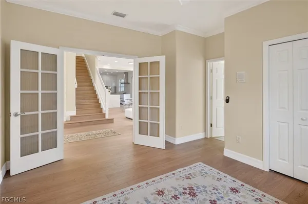a view of a big room with wooden floor and windows